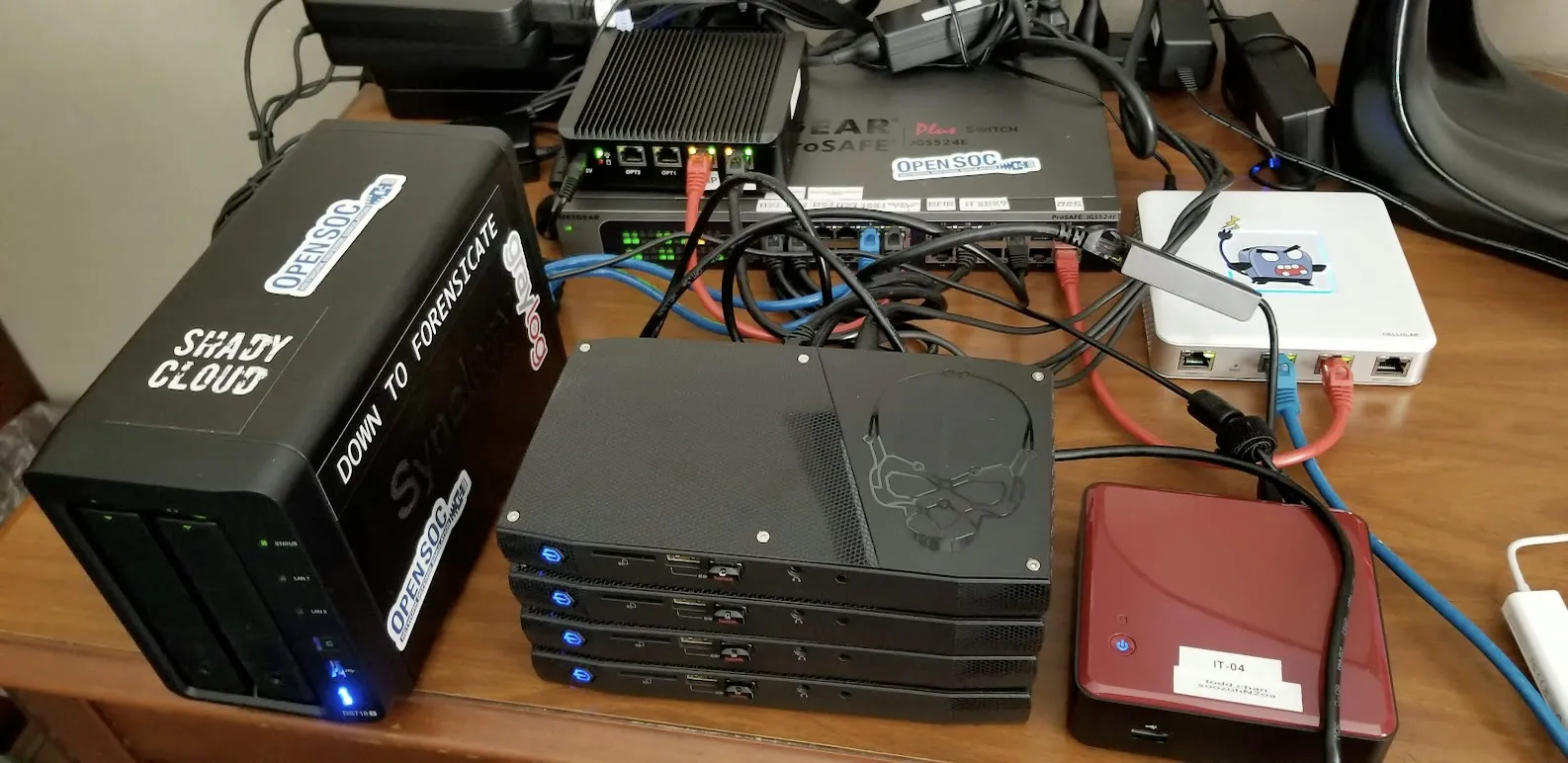 The early OpenSOC range: a Synology NAS, stacked mini PCs and a network switch wired together on a desk
